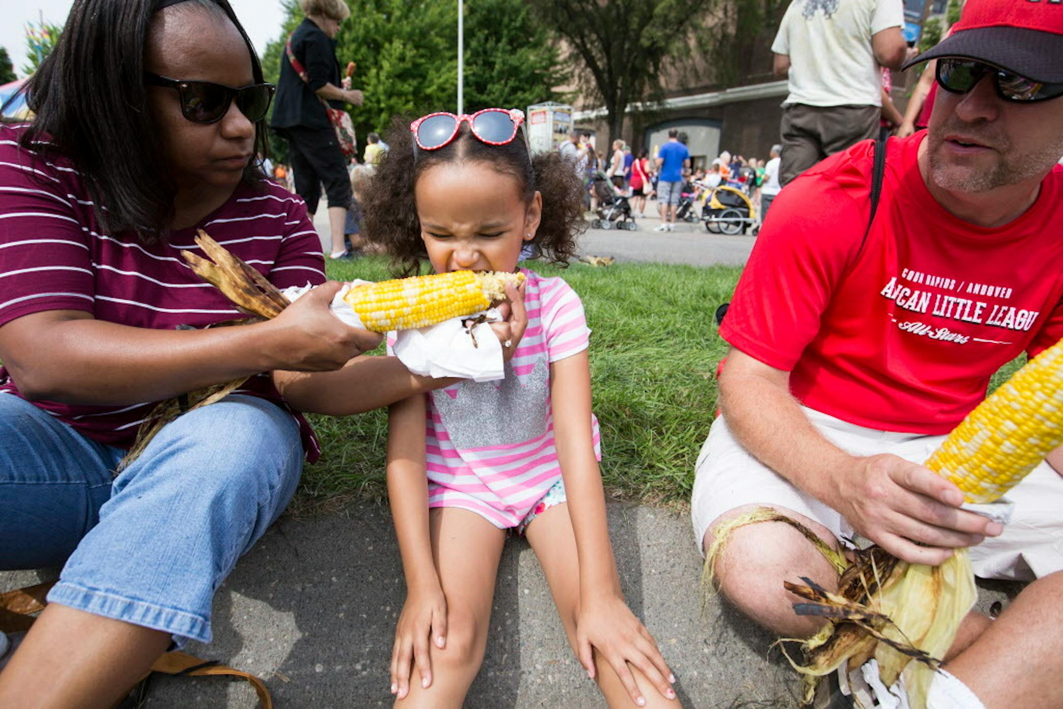 Diane Thoemke of Coon Rapids feeds her daughter Peyton, 6, roasted corn as dad Steve looks on. ] (Leila Navidi/Star Tribune) leila.navidi@startribune.com BACKGROUND INFORMATION: Food at the Minnesota State Fair on Thursday, August 25, 2016. Rick Nelson reviews the new food this year.