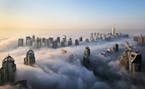 Morning fog partly shrouds the skyscrapers of the Marina and Jumeirah Lake Towers districts of Dubai, United Arab Emirates. Dubai — writes Quinn Slo