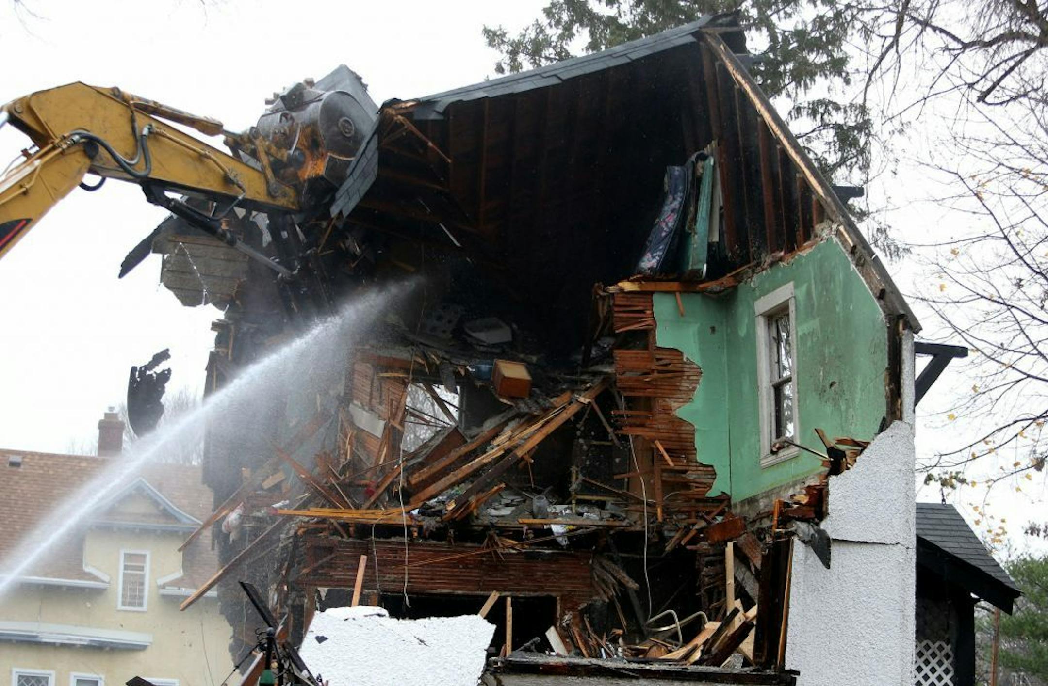 The demolition company BRC of Stillwater MN, took down a fire-damaged house in the 1000 block of north Minneapolis Thursday, Nov. 12, 2015.