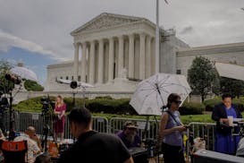 Reporters work outside of the Supreme Court in Washington on June 27.