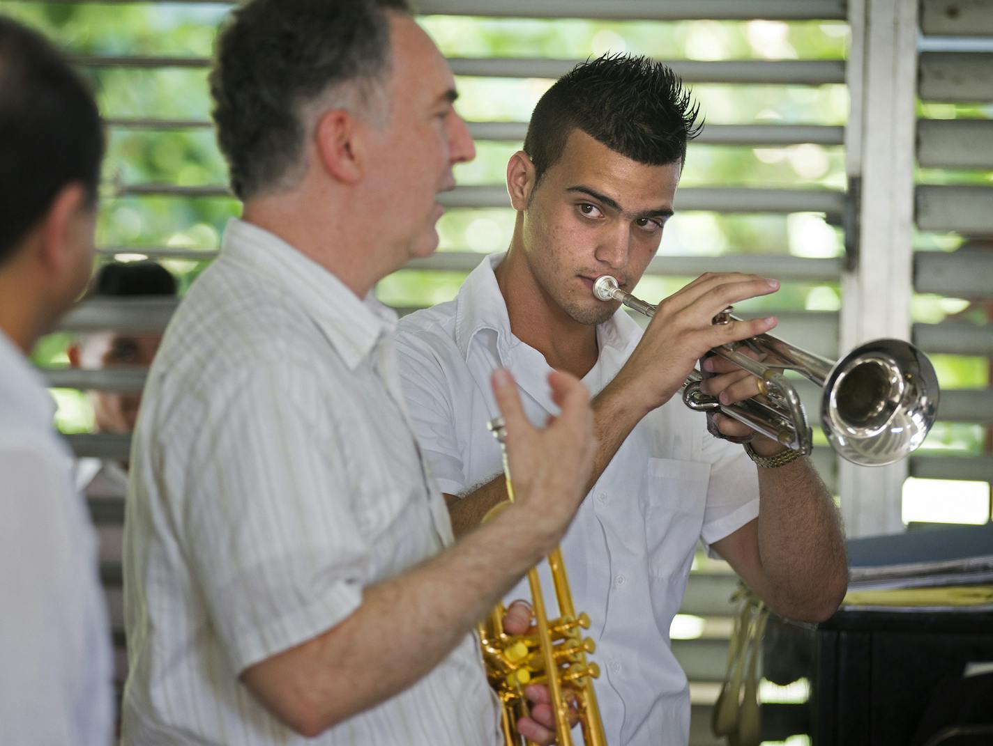 Minnesota Orchestra trumpeter Robert Dorer, center, gave student Antonio Diaz Martinez some tips during a visit to Cuba&#x2019;s Escuela Nacional de M&#xfa;sica in Havana. In addition to mentoring young musicians, the orchestra players brought needed supplies.