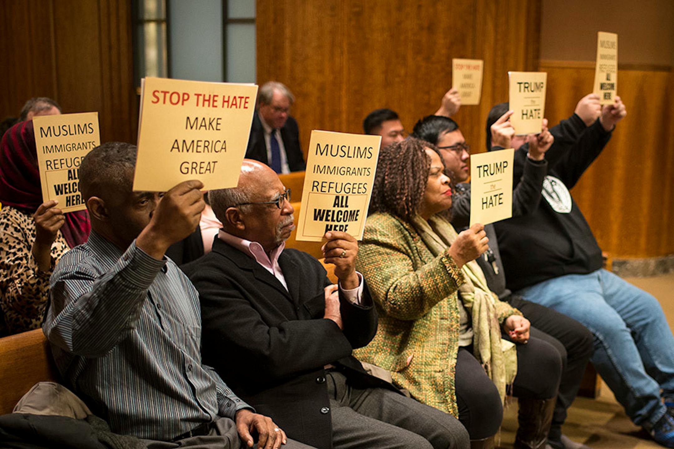Demonstrators held signs voicing their support for a city council resolution condemning Republican presidential candidate Donald Trump for anti-Muslim, anti-refugee and anti-immigrant speech Wednesday night.