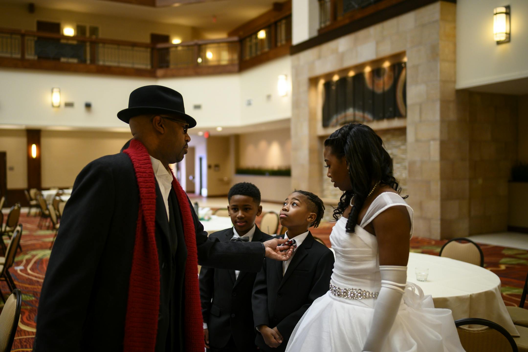 Osseo sophomore Nyila Green watched as her father, John adjusted to bowtie of her brothers Braxton, 10, right of center, and Talon, 9, before they took photos prior to the start of Saturday's debutante ball.