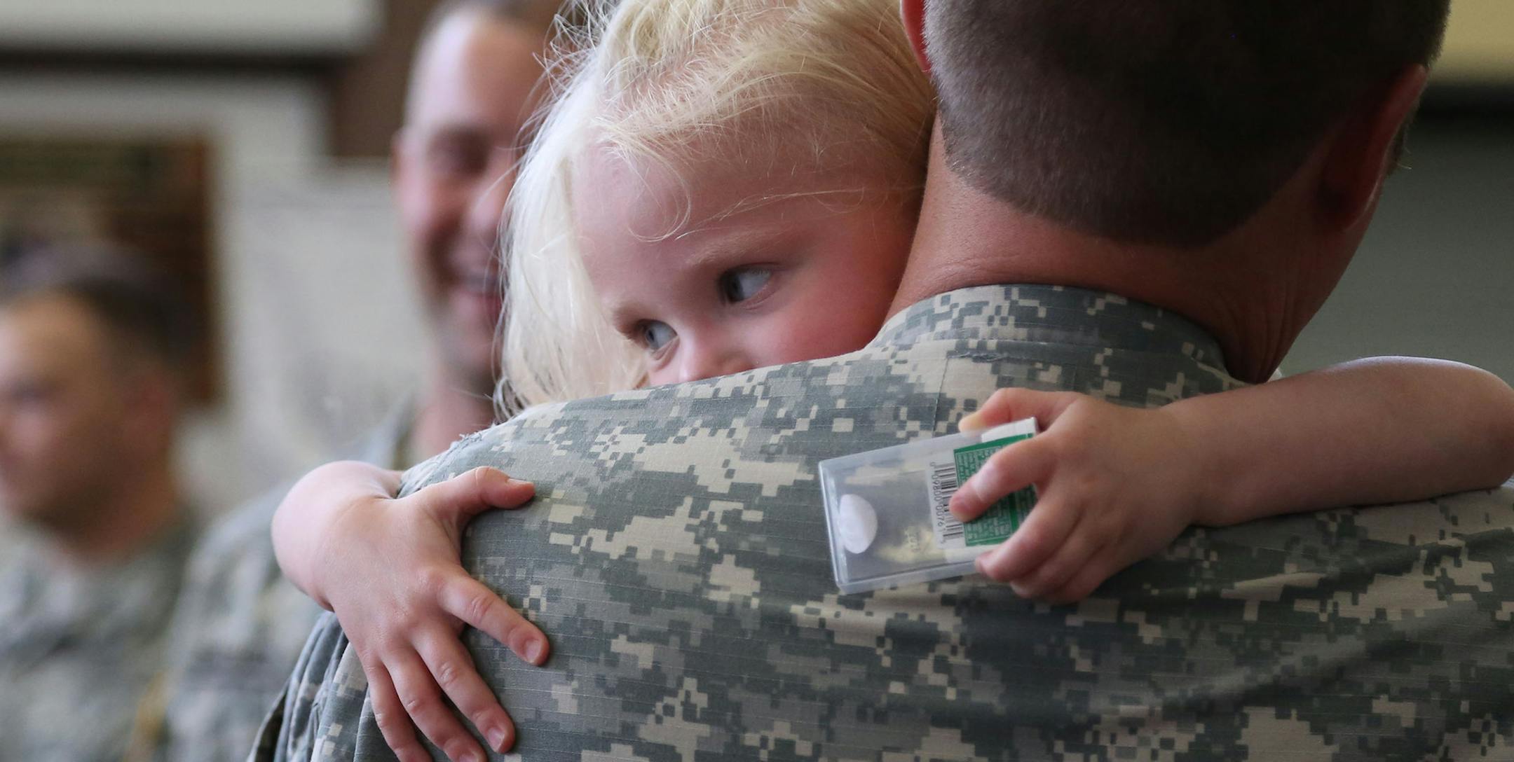 Liv Sigerson, 2, acted shy around the other soldiers as he father Sgt First Class Michael Sigerson held her after the ceremony. ] (KYNDELL HARKNESS/STAR TRIBUNE) kyndell.harkness@startribune.com Forty-two soldiers from the Minnesota National Guard's 204th Area Support Medical Company had a welcome home ceremony at Century College in White Bear Lake , Min., Saturday August 29, 2015. ORG XMIT: MIN1508291701210199
