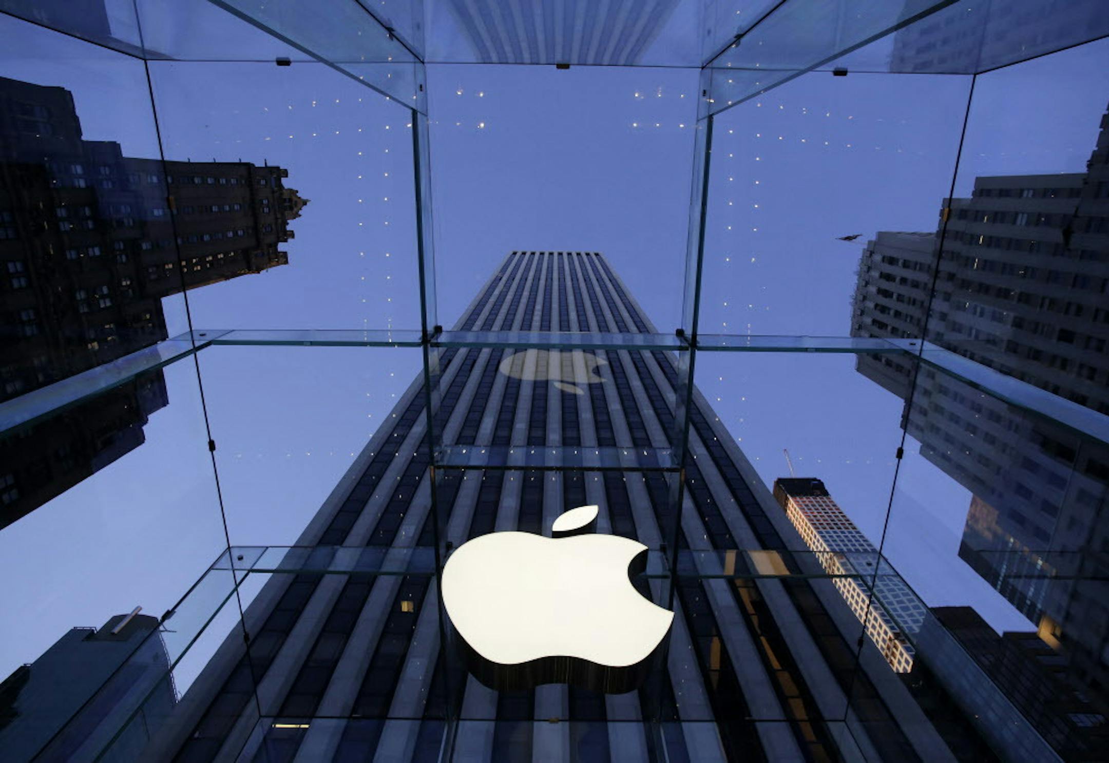 The Apple logo hangs in the glass box entrance to the company's Fifth Avenue store, in New York.