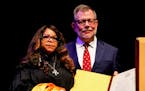 Prince's sister, Tyka Nelson, left, stands with then-University of Minnesota President Eric Kaler, when he presented an honorary degree posthumously t