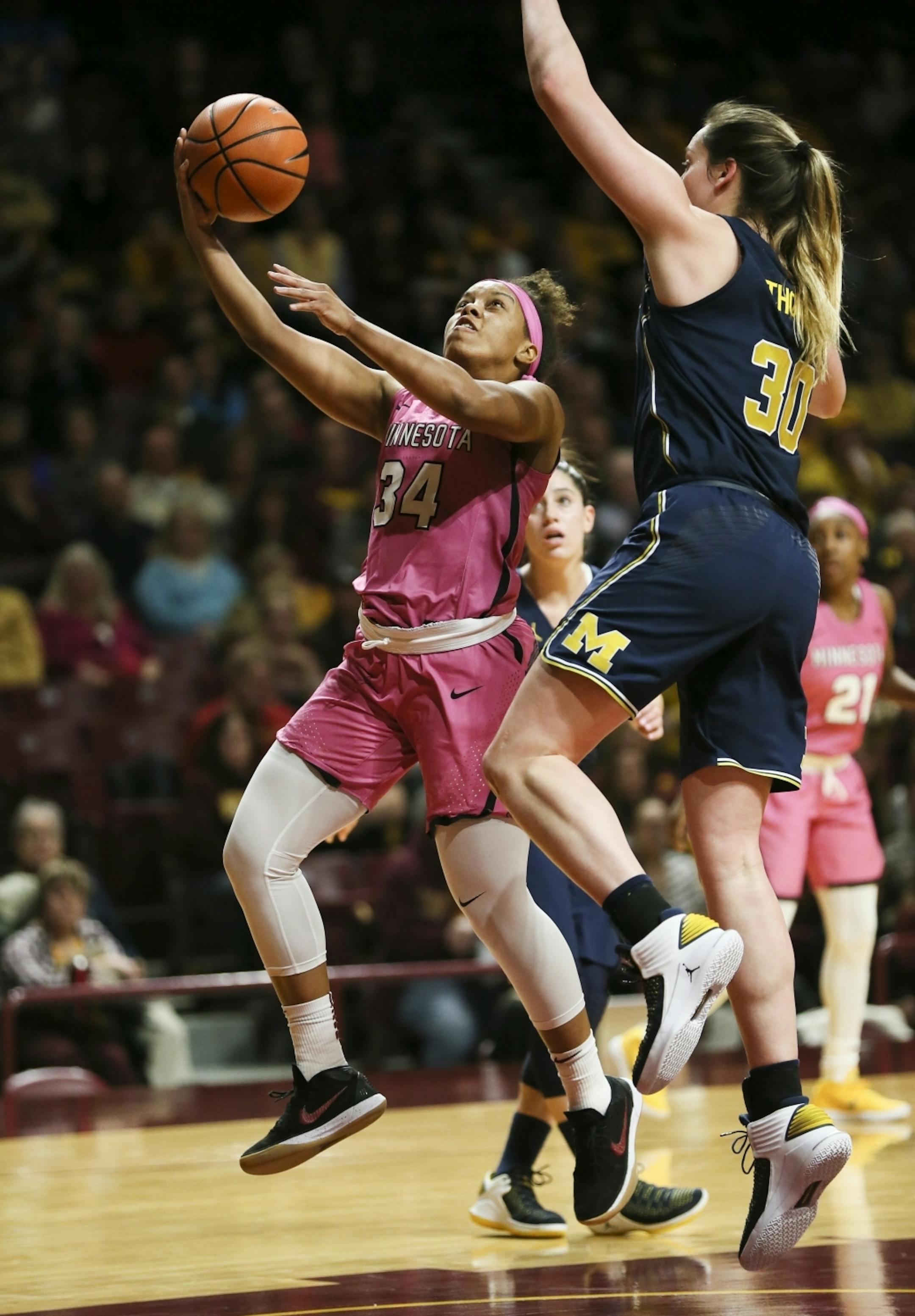 Minnesota Golden Gophers guard Gadiva Hubbard (34) jumped for a shot as Michigan Wolverines Hallie Thome (30) tried to block in the first half