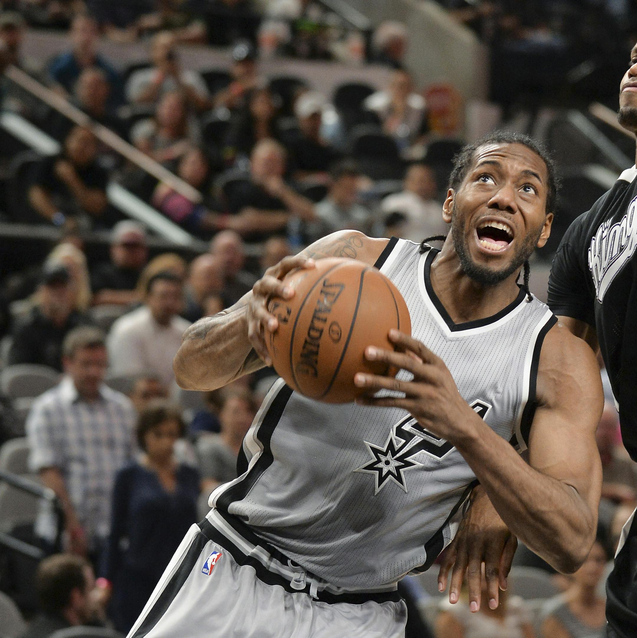San Antonio Spurs forward Kawhi Leonard, left, attempts to shoot against Sacramento Kings forward Rudy Gay during the second half of an NBA basketball game, Saturday, March 5, 2016, in San Antonio. San Antonio won 104-94. (AP Photo/Darren Abate) ORG XMIT: MIN2016041516362527