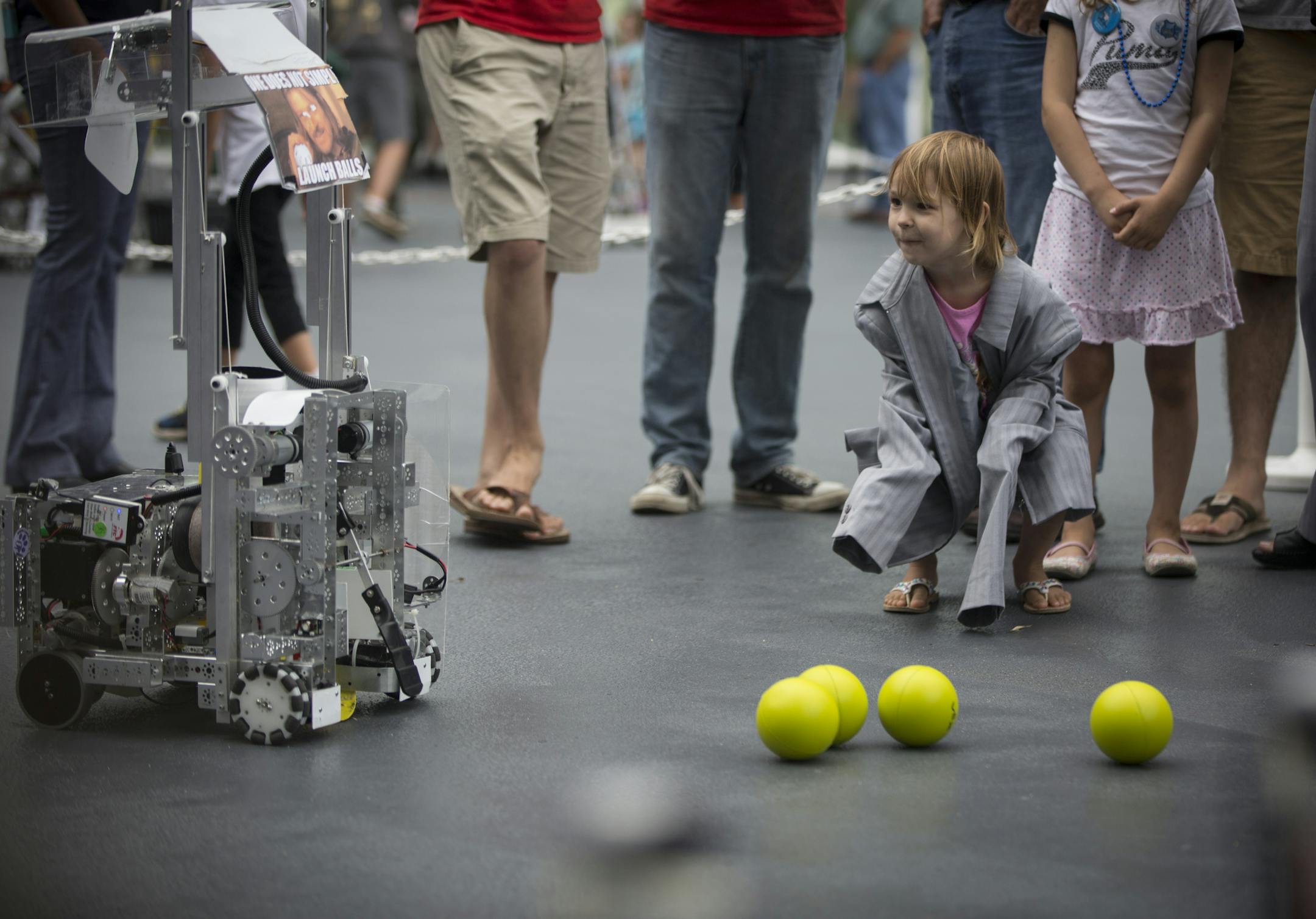 Jillian Kuchar, 3, wearing her mom Julie Luchar's blazer, laughed as she watched a ball-shooting-robot, made by the Eagan High School robotics team, drive past her at an event that had local high school students from the 14 area school's 3M sponsors in Robotics showing off incredible robots they made themselves at the 3M plaza on Thursday, August 7, 2015 in Woodbury, Minn. Family of 3M employees were invited to see and test out the robots. Julie Luchar is a 3M employee. ] RENEE JONES SCHNEIDER &