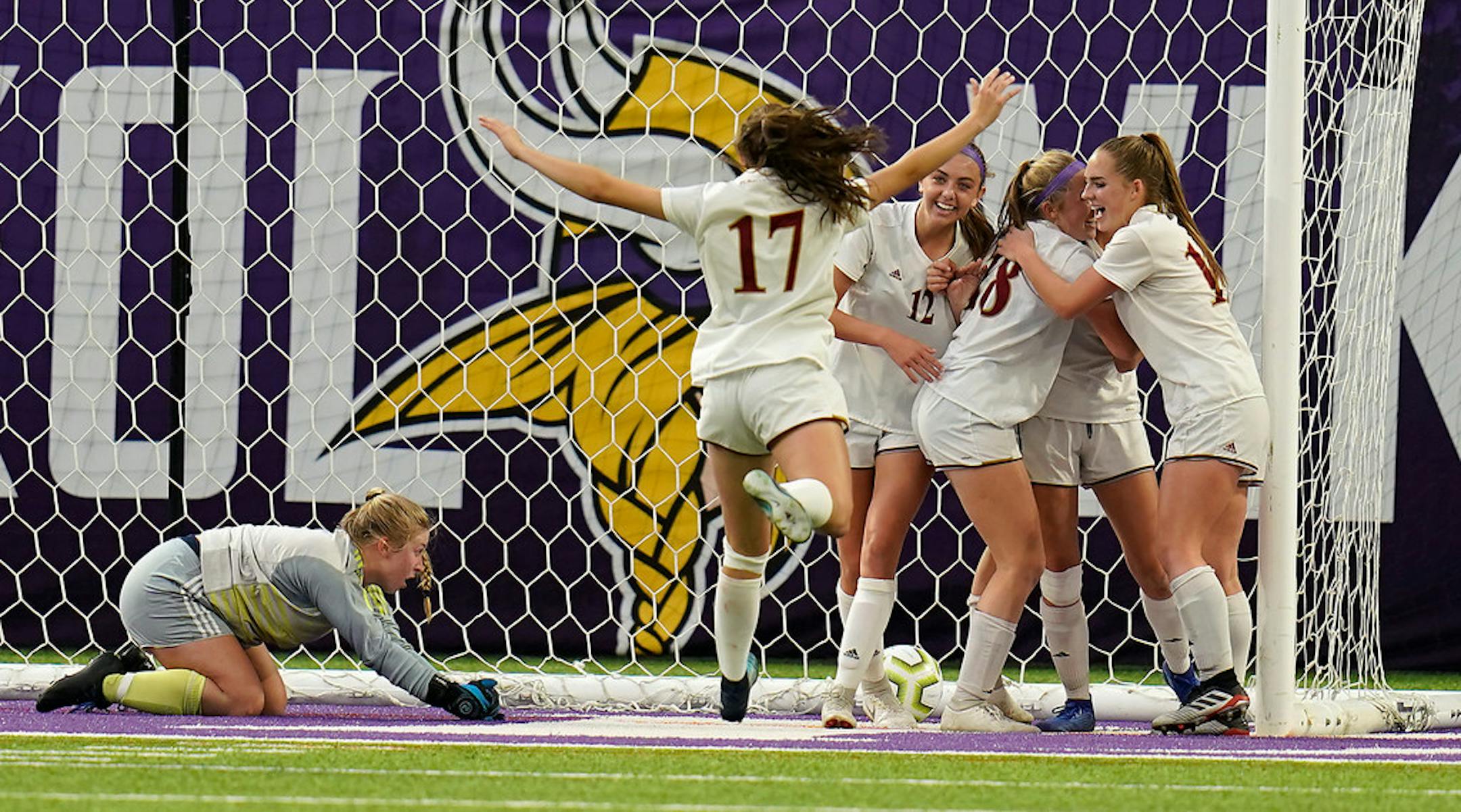 Maple Grove players celebrated a goal by Maple Grove midfielder Lauren Bredensteiner (12), center facing camera, in the second half as Champlin Park goalkeeper Sarah Martin (0) laid on the ground.