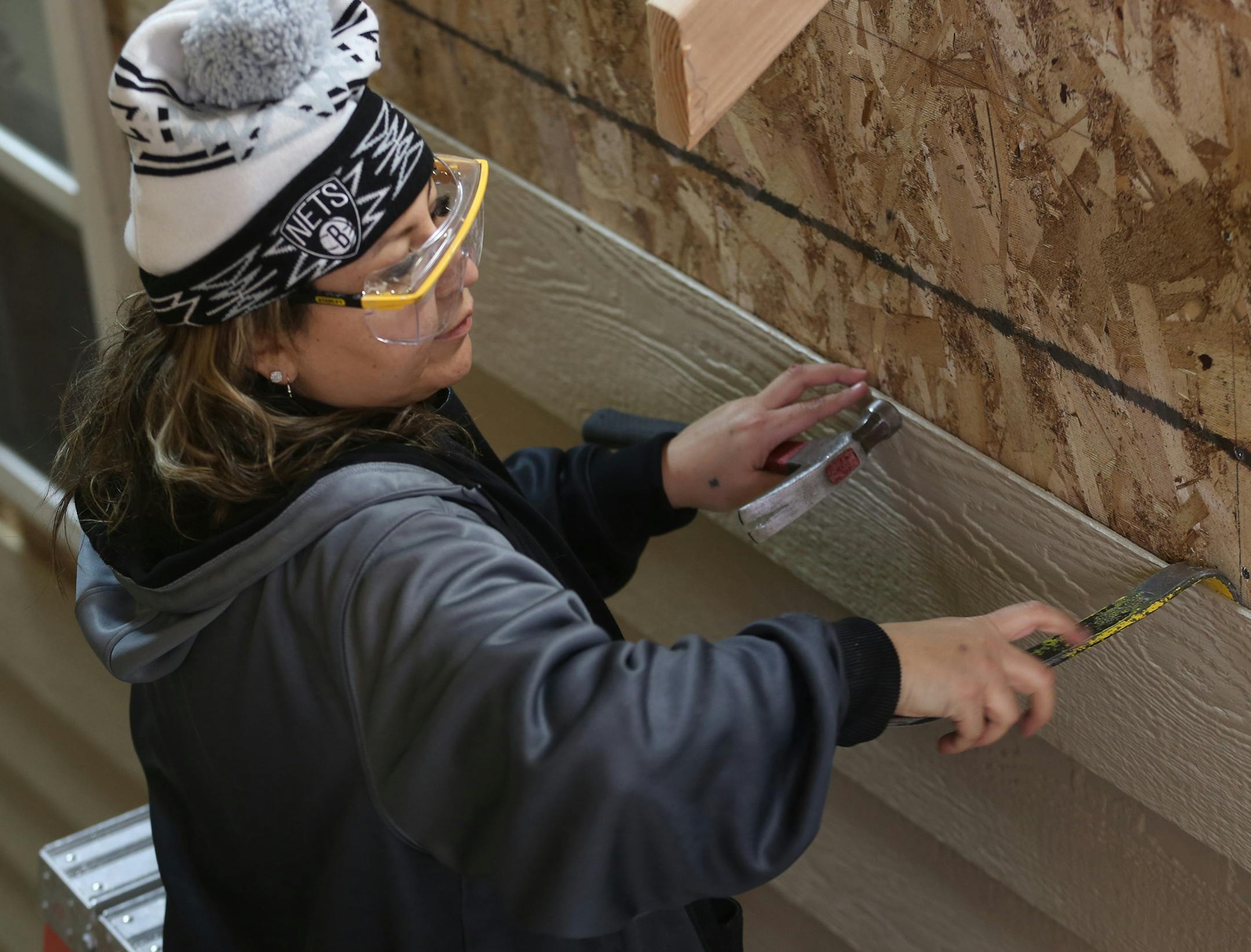 McKenzie Reynolds, 37, of St Paul, pried off the siding of one of the houses. ] (KYNDELL HARKNESS/STAR TRIBUNE) kyndell.harkness@startribune.com A 12 week construction trade program at Goodwill-Easter Seals in St Paul Min., Tuesday, January 6, 2014. The state just invested $500,000 in 7 grants to train women in manufacturing, truck driving and construction. Goal is to boost women's pay and narrow the gender gap.
