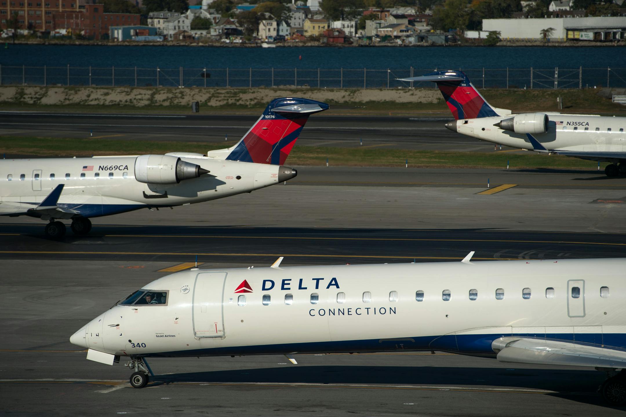 Delta Air Lines Inc. planes sit on the runway at LaGuardia Airport (LGA) in New York, U.S., on Monday, Oct. 21, 2013. Delta Air Lines Inc. is scheduled to release earnings figures on Oct. 22. Photographer: Ron Antonelli/Bloomberg