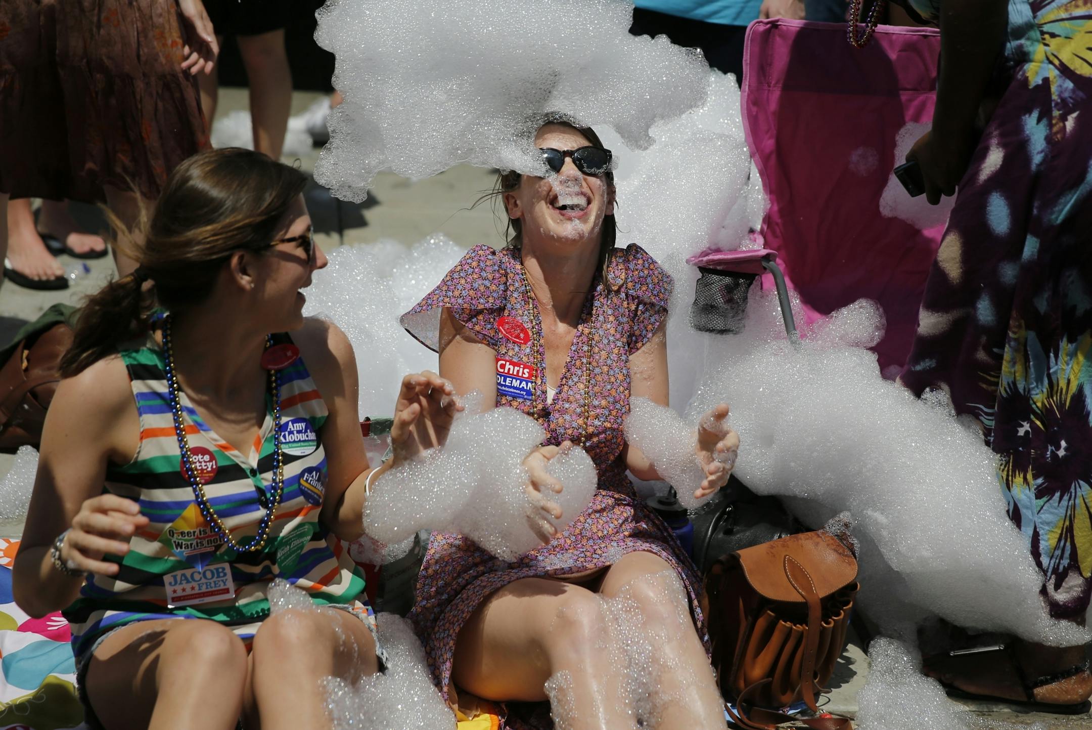 At the gay pride parade on Hennepin Avenue, Sarah Kiefer looked on as Britta Carlson got soaked with soap foam from the Gay 90's foam party float.