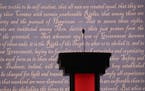 A podium in front of a video graphic of script from the Declaration of Independence at the venue for tonight's first debate between the presidential n