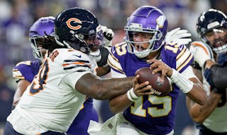 Minnesota Vikings quarterback Joshua Dobbs (15) slips away from Gervon Dexter Sr. of the Chicago Bears in the second quarter Monday, November 27, 2023