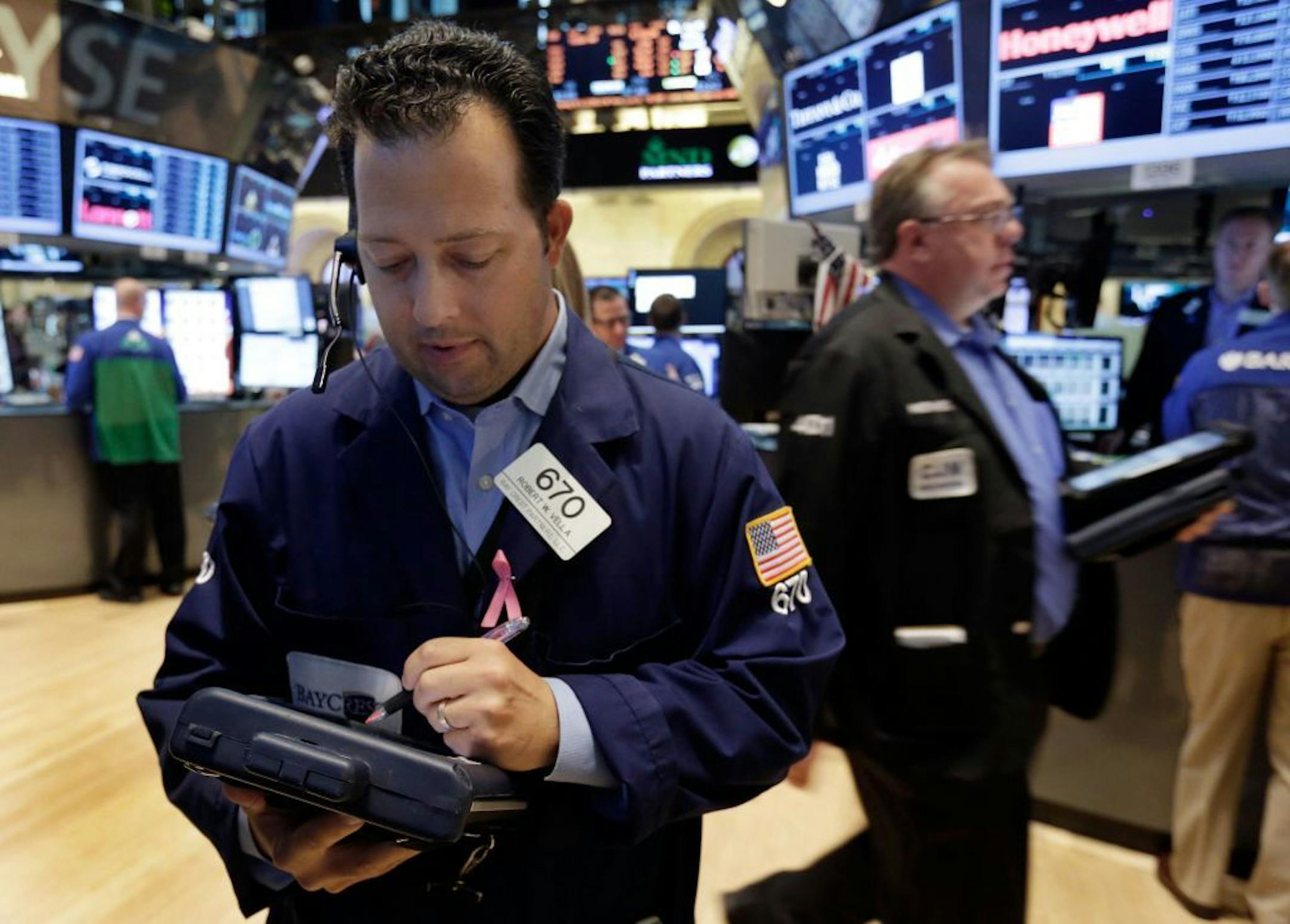 In this Friday, June 28, 2013 photo, trader Robert Vella, left, works on the floor of the New York Stock Exchange. U.S. stocks are getting off to a slow start after a three-day rally. U.S. stock futures are rising with industry watchers expecting automakers to post banner sales. The government also releases its May factory orders report Tuesday, July 2, 2013, and economists are looking for signs of an extended recovery in manufacturing.