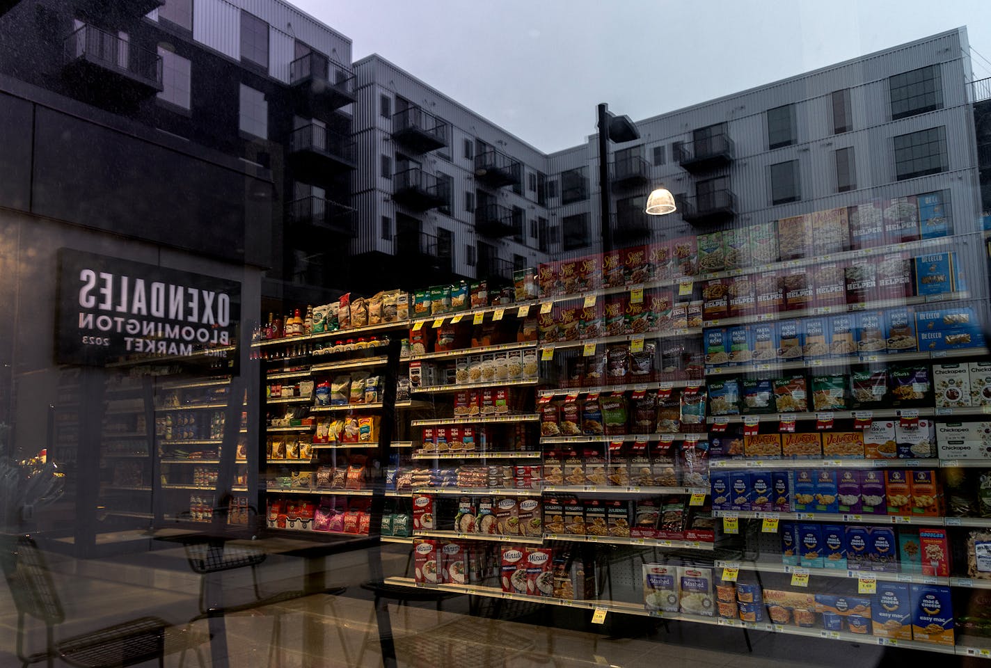 Merchandise left on shelves at the recently closed Oxendale's Market and reflections of the Carbon31 Apartments Wednesday, February 14, 2024, in Bloomington, Minn. Bloomington has been trying to build a city-like walkable neighborhood from scratch near the Mall of America. A grocery store was supposed to be the linchpin of development in the area, and when it opened in November the city was saying the neighborhood had really arrived. Then, the store closed -- on the heels of a coffee shop closing nearby, and developers deciding not to build more commercial in the area.   ] CARLOS GONZALEZ • carlos.gonzalez@startribune.com