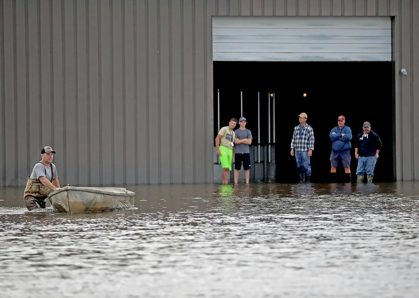 Men were on hand to help sand the ice arena near Waseca High School on Thursday after almost 10 inches of rain fell in town over two days.