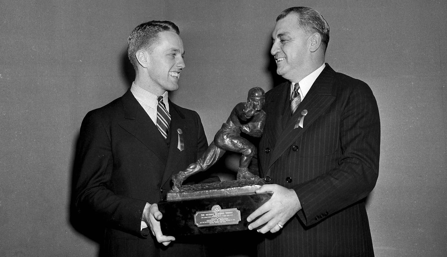 Captain of the University of Minnesota Bruce Smith, left, receives the Heisman trophy from Joseph R. Taylor of the Downtown Athletic Club in New York, Dec. 9, 1941. (AP Photo)