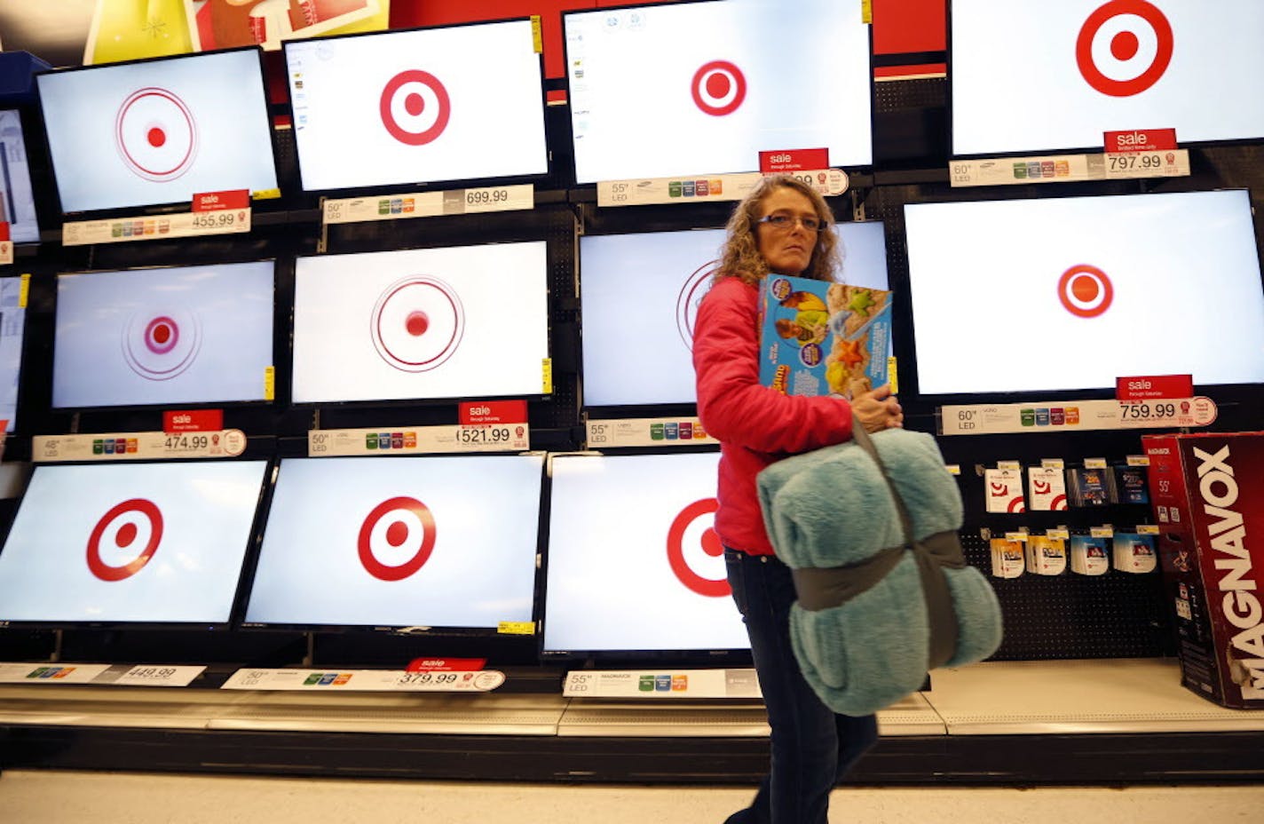 FILE - In this Nov. 28, 2014, file photo, a customer walks past a bank of flat screen televisions at a Target store in South Portland, Maine. Target reports financial results Wednesday, May 18, 2016. (AP Photo/Robert F. Bukaty, File)