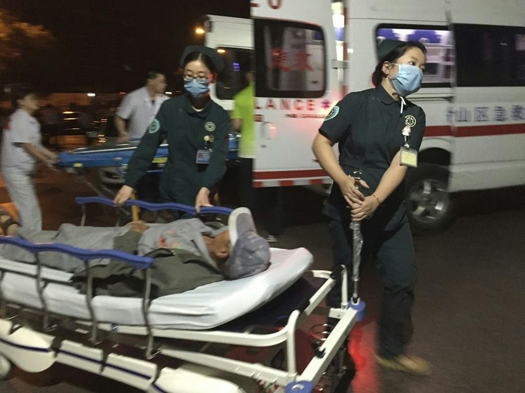 In this photo released by China's Xinhua News Agency, medical workers transport a person injured in an explosion outside a kindergarten into a hospital in Fengxian County in eastern China's Jiangsu Province early Friday, June 16, 2017. Several people were killed and dozens more injured in an explosion Thursday at the front gate of the kindergarten in eastern China as relatives were picking up their children at the end of the school day, local officials said.