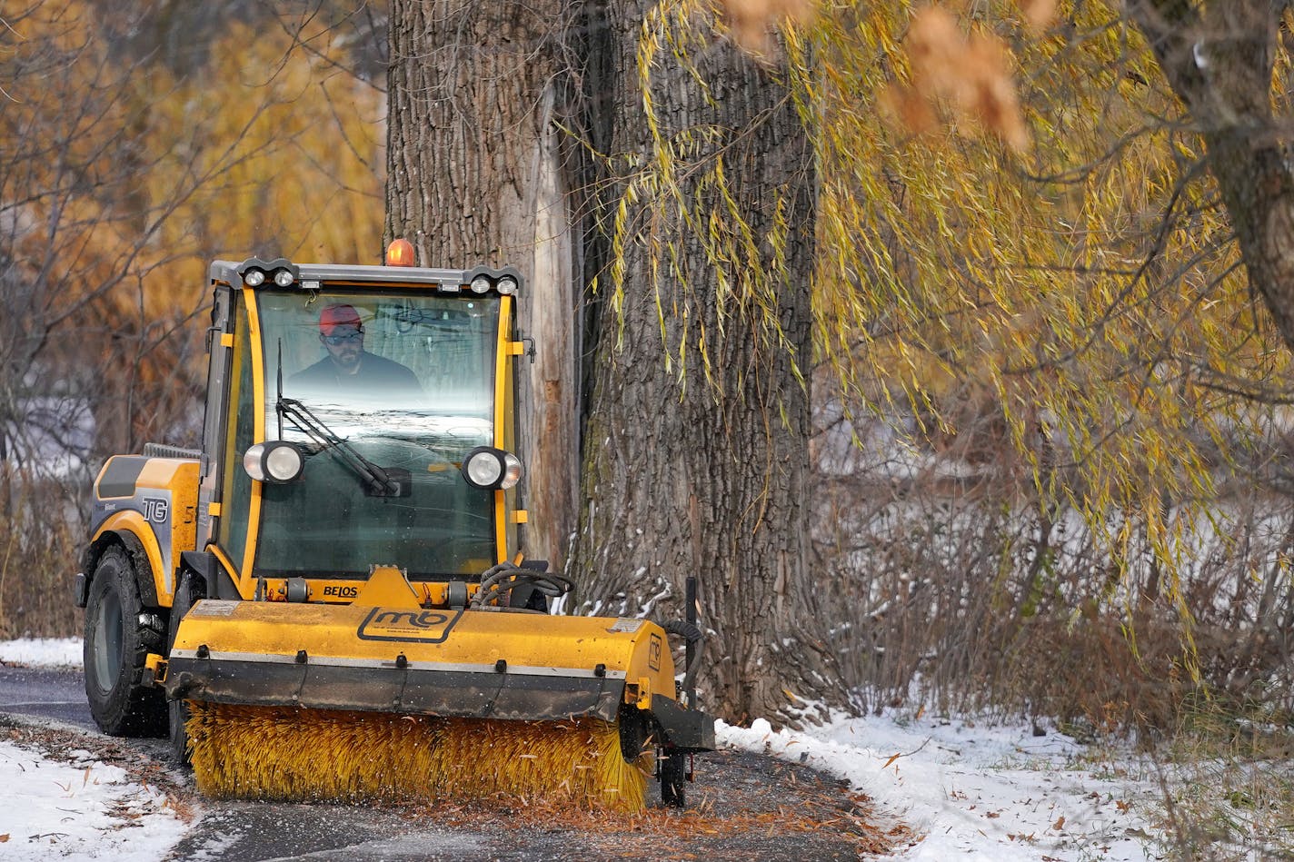 David Beckermann, a park maintenance worker with the city of Roseville, cleared the path of snow, ice, and leaves Friday afternoon at Central Park. ] ANTHONY SOUFFLE &#xef; anthony.souffle@startribune.com City workers cleared sidewalks of snow, ice, and leaves Friday, Nov. 9, 2018 in Roseville, Minn.