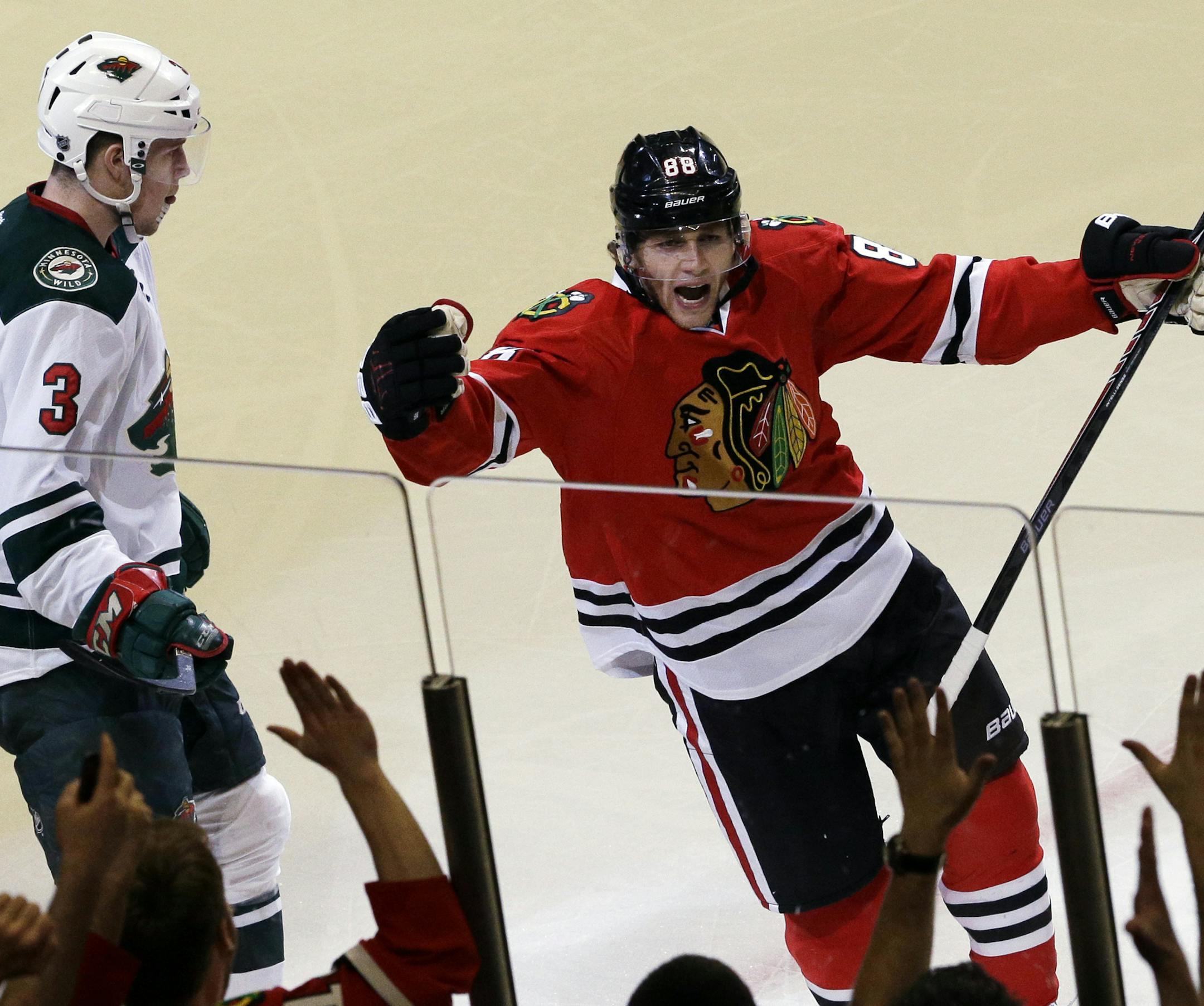 Chicago Blackhawks' Patrick Kane (88), right, celebrates after scoring his goal as Minnesota Wild's Charlie Coyle (3) looks down during the third period in Game 1 of an NHL hockey second-round playoff series in Chicago, Friday, May 2, 2014. The Blackhawks won 5-2. (AP Photo/Nam Y. Huh)