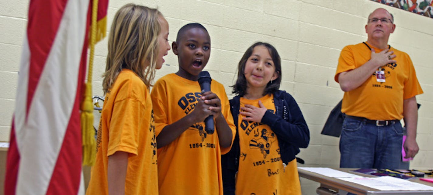 Osseo Elementary School second-grade students, from left, Calissa Plocharski, Nick Williams and Aimee Castaneda led the Pledge of Allegiance at the school's final assembly. Principal Phil Sadler stood at attention at the side of the trio.