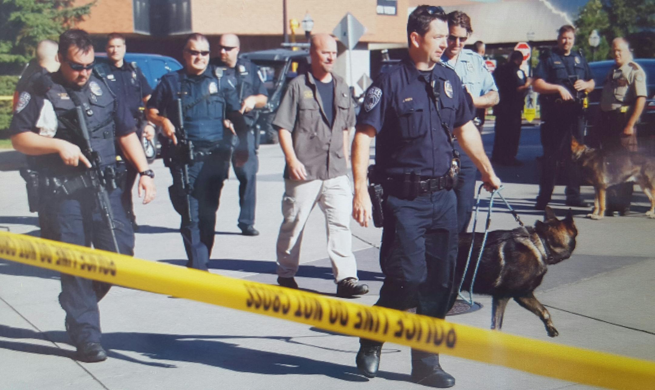 A team of dogs and police make their way down to the East River Road Garage next to Coffman Memorial Union to continue their search of the premises.