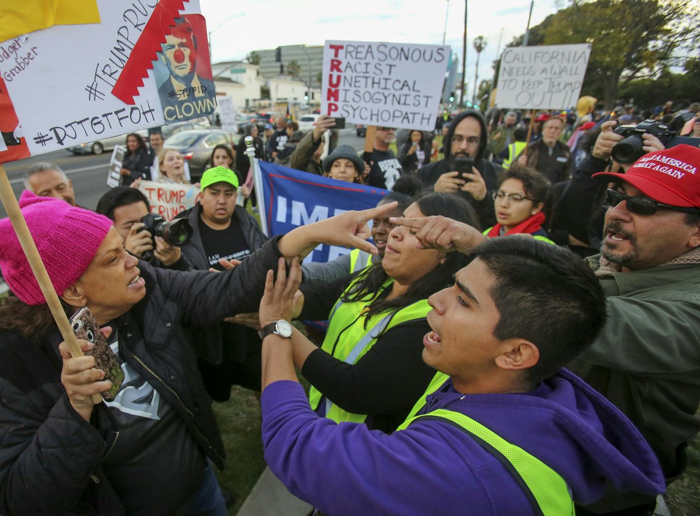 A Trump supporter, far right, and an anti-Trump supporter, left, confront each other during a rally against a visit by President Donald Trump, Tuesday, March 13, 2018, in Beverly Hills, Calif. (AP Photo/Ringo H.W. Chiu) ORG XMIT: CARC110