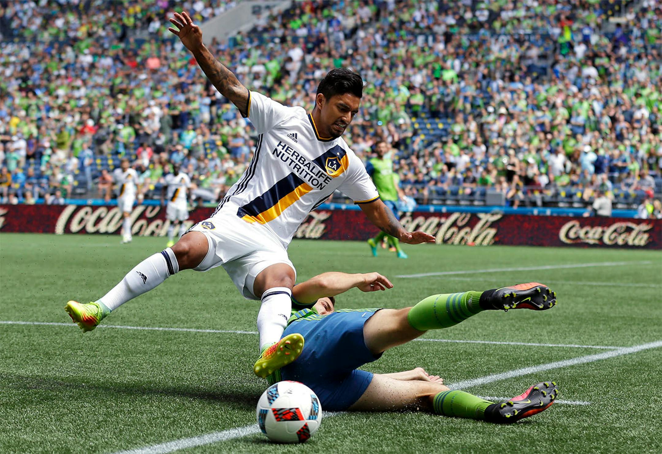 Los Angeles Galaxy defender A. J. DeLaGarza, left, goes down as he is tackled by Seattle Sounders midfielder Jordan Morris, right, in the first half of an MLS soccer match, Sunday, July 31, 2016, in Seattle.