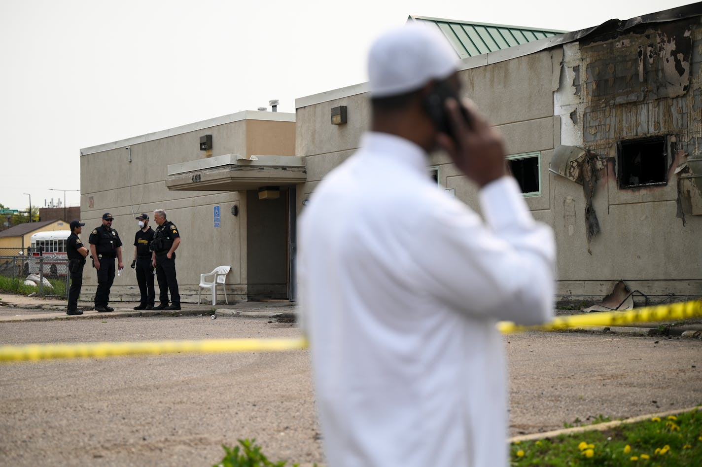 Police and community members gathered outside the burned-out Tawhid Islamic Center in St. Paul on Wednesday.