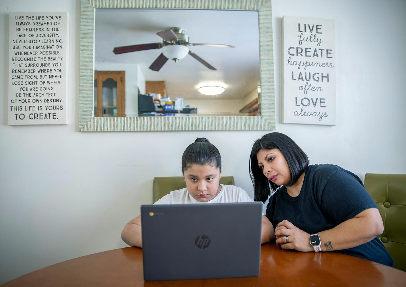 Claudia Sandoval, right, assisted her daughter Natalie, 10, with her math from her home, Tuesday, February 9, 2021 in Maplewood, MN. Sandoval, who works in the banquet department for a hotel, said that it will be a while before her department will be called bak to work. ] ELIZABETH FLORES • liz.flores@startribune.com ORG XMIT: MIN2102091511470027