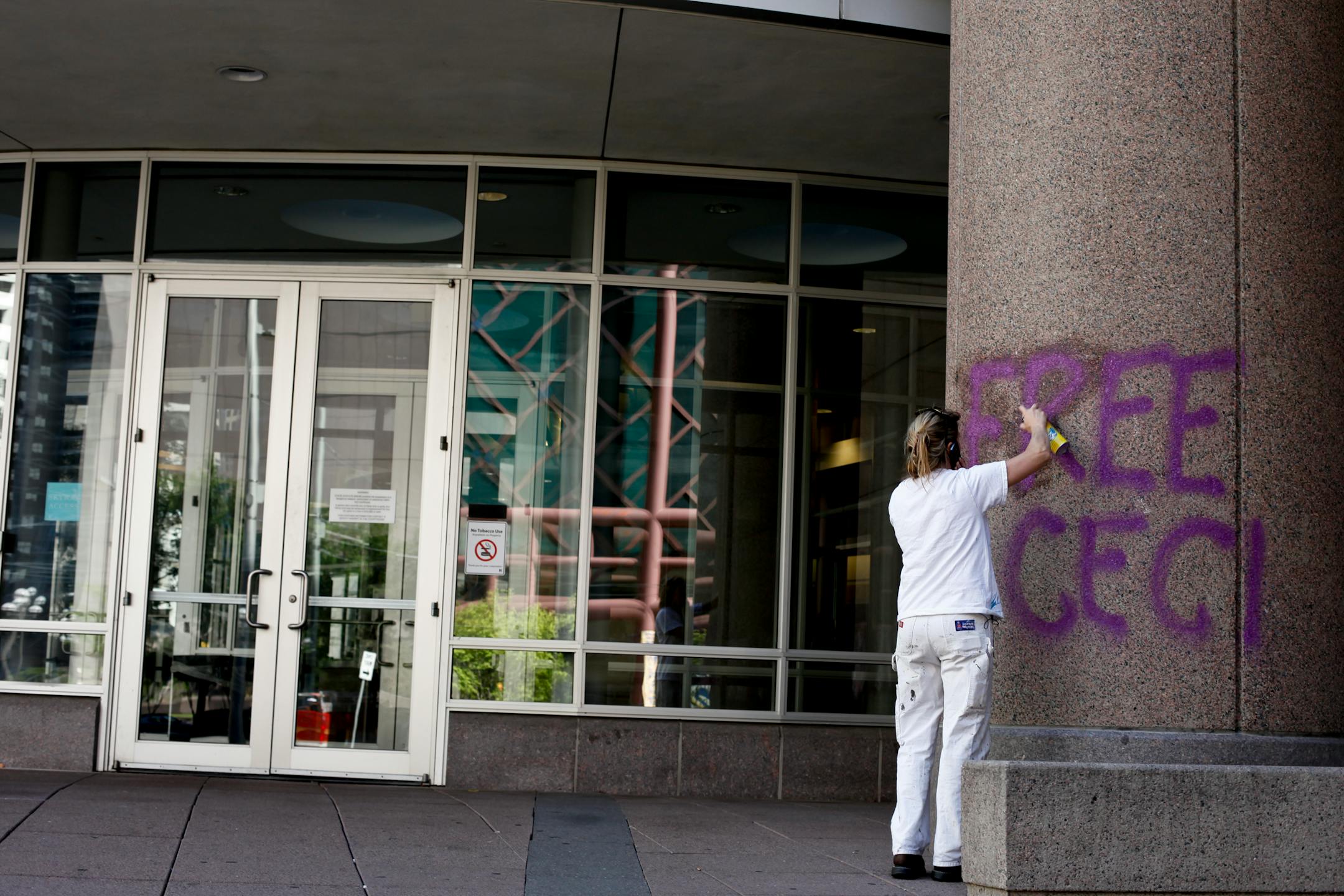 Chari Jenson, 38, employee of Universal Painting and Drywall erases Graffiti that reads "Free CeCi Now!" from the jail located at 401 S. 4th St. Minneapolis, Minn. on Tuesday July 5, 2012.