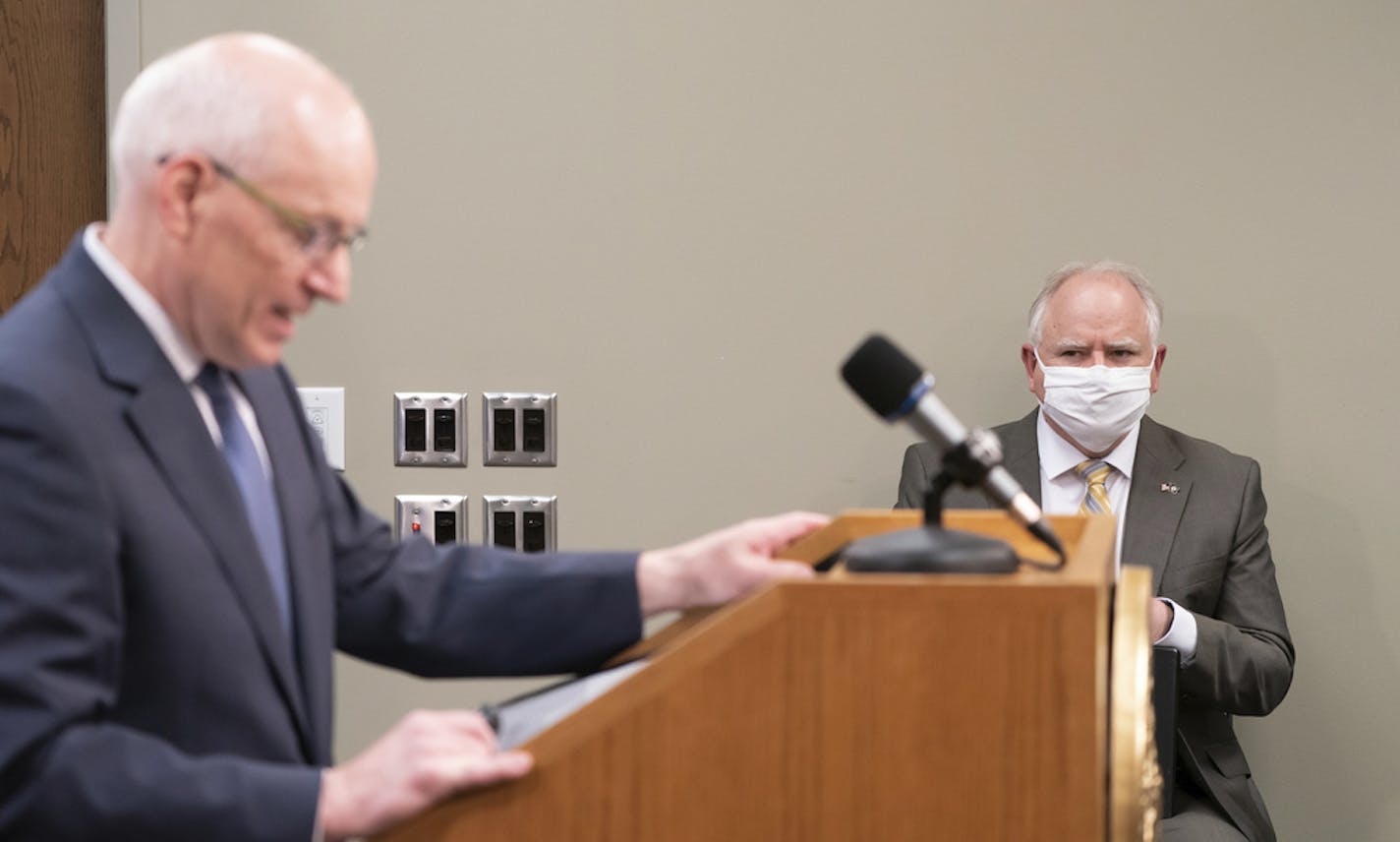 Governor Tim Walz listens as MMB Commissioner Myron Frans talks about the State of Minnesota's budget projection. The state's budget outlook crumbled from a $1.5 billion surplus to a projected $2.4 billion deficit in just two months, as the COVID-19 pandemic eats up tax revenue and Minnesota leaders accelerate spending to respond. (Glen Stubbe/Star Tribune via AP)