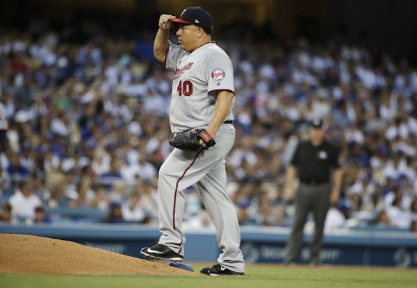 Minnesota Twins starting pitcher Bartolo Colon walks onto the mound to throw during the third inning of a baseball game against the Los Angeles Dodger