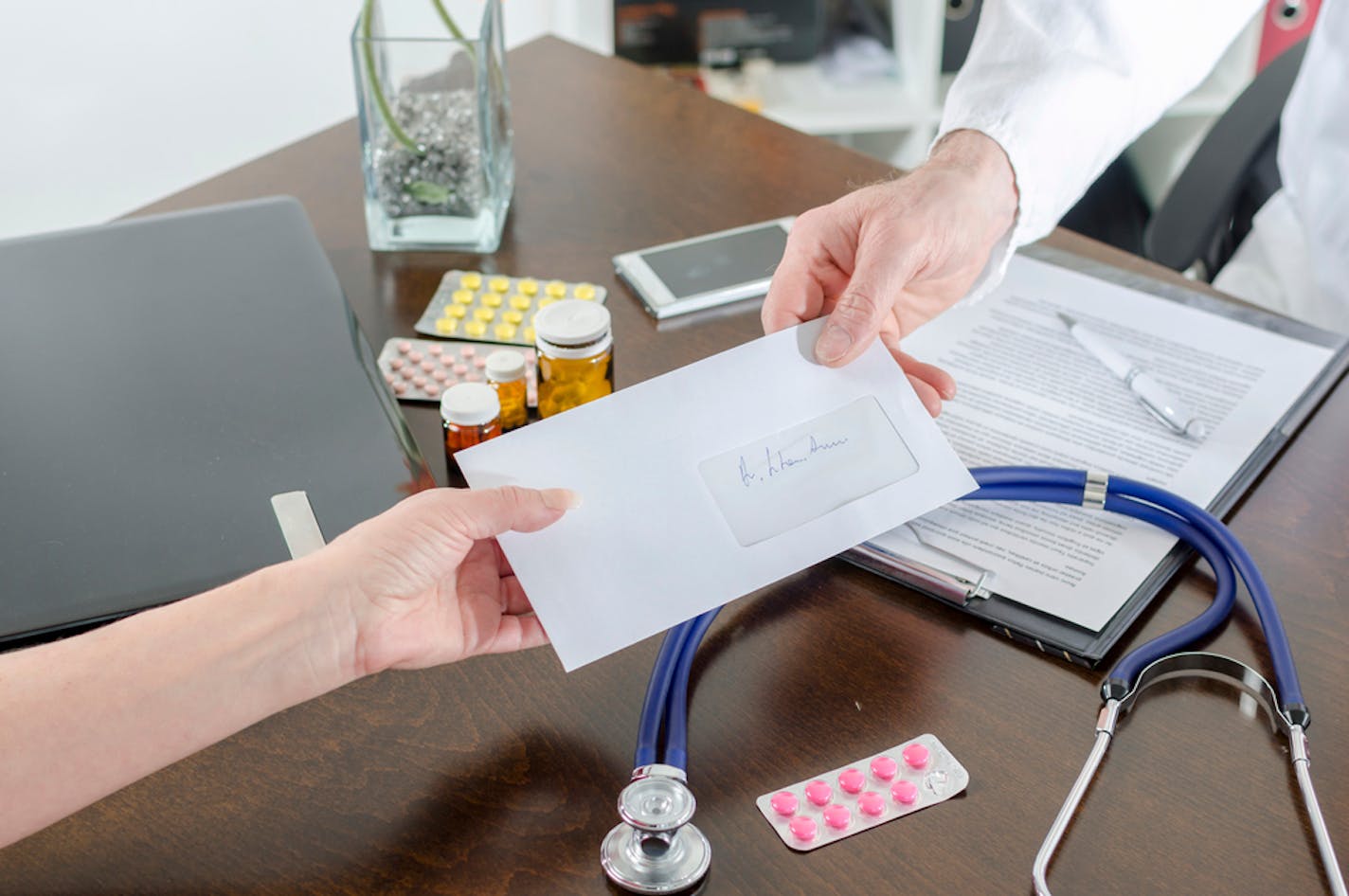 Doctor giving a prescription to his patient in medical office. istock photo