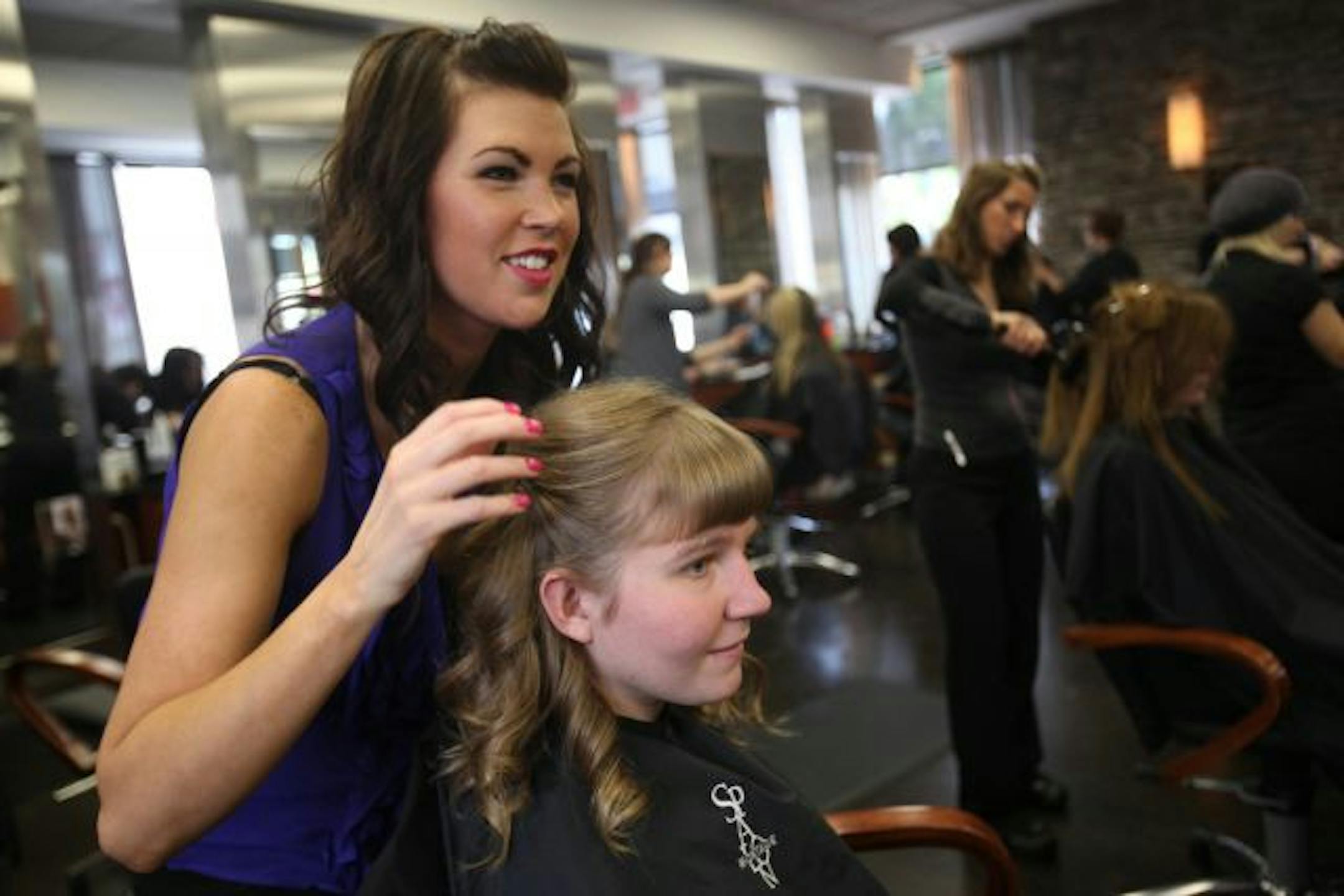 Anda Moettus smiled along with stylist Rebecca Kirk of Spalon Montage after Kirk finished pinning back her curled tendrils.