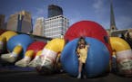 July 22, 2009: A child emerged from a giant blow-up caterpillar set up in the parking lot of First Baptist Church on Hennepin Ave. before the Aquatenn