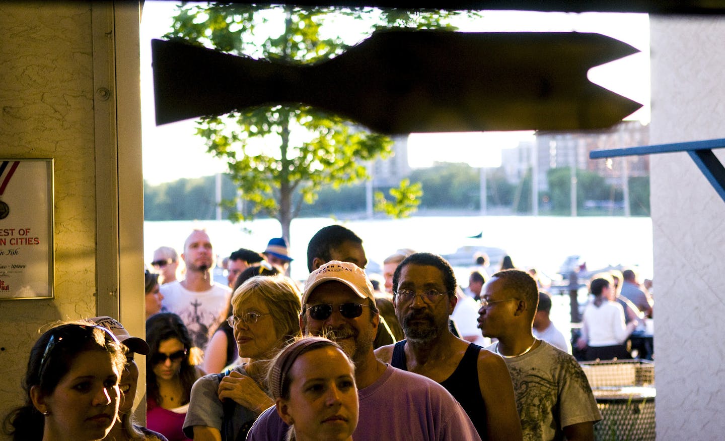 BRENDAN SULLIVAN? brendan.sullivan@startribune.com MINNEAPOLIS - July 20, 2010 - People eating at the Tin Fish on Tuesday evening besides Calhoun Lake. IN THIS PHOTO: ] A line of about three dozen people wait to order food at The Tin Fish on Tuesday evening. Minneapolis Park Board is looking for ways to raise more money and one option is to open more concession stands such as The Tin Fish. ORG XMIT: MIN2017111520480535