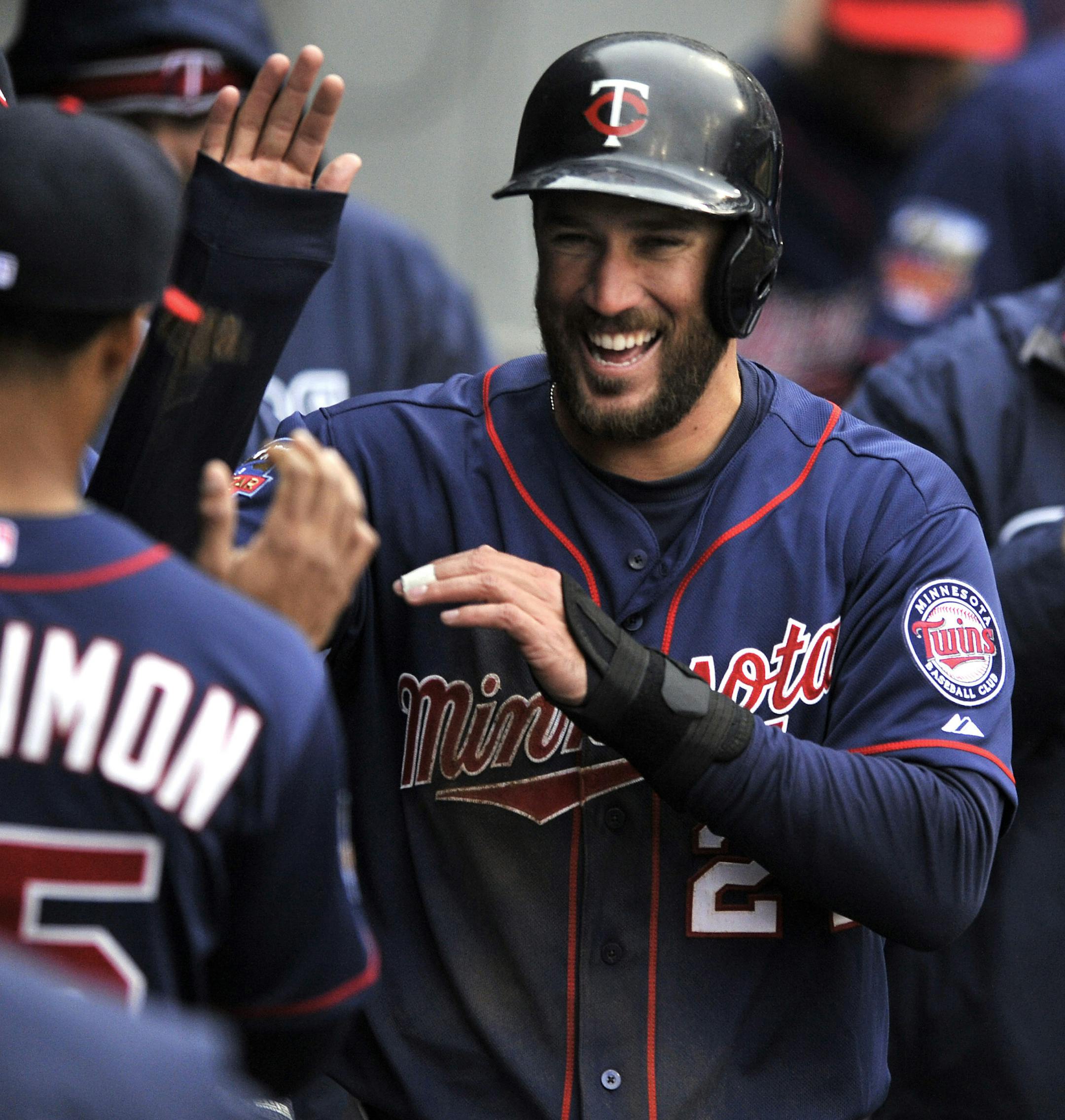 Minnesota Twins' Trevor Plouffe (24) celebrates with teammates after scoring on an Oswaldo Arcia go-ahead triple during the ninth inning of a baseball game against the Chicago White Sox in Chicago, Thursday, April 3, 2014. Minnesota won 10-9. (AP Photo/Paul Beaty)