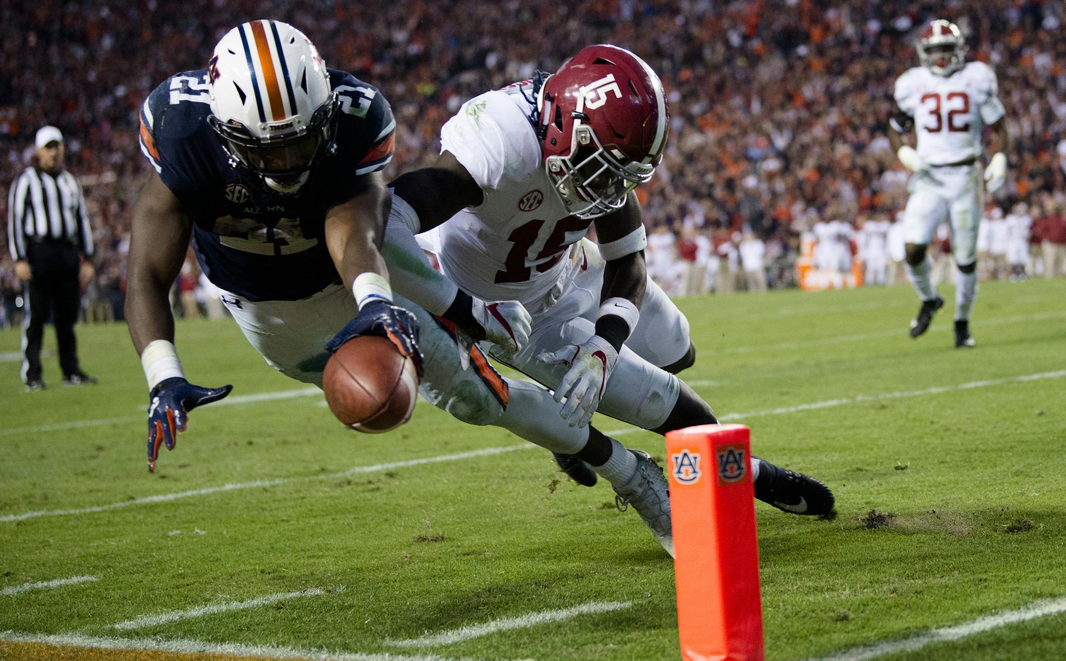 Auburn running back Kerryon Johnson (21) dives for the end zone and gets a first down as Alabama defensive back Ronnie Harrison (15) knocks him out of bounds during the Iron Bowl NCAA football game Saturday, Nov. 25, 2017, in Auburn, Ala. (Albert Cesare/The Montgomery Advertiser via AP)