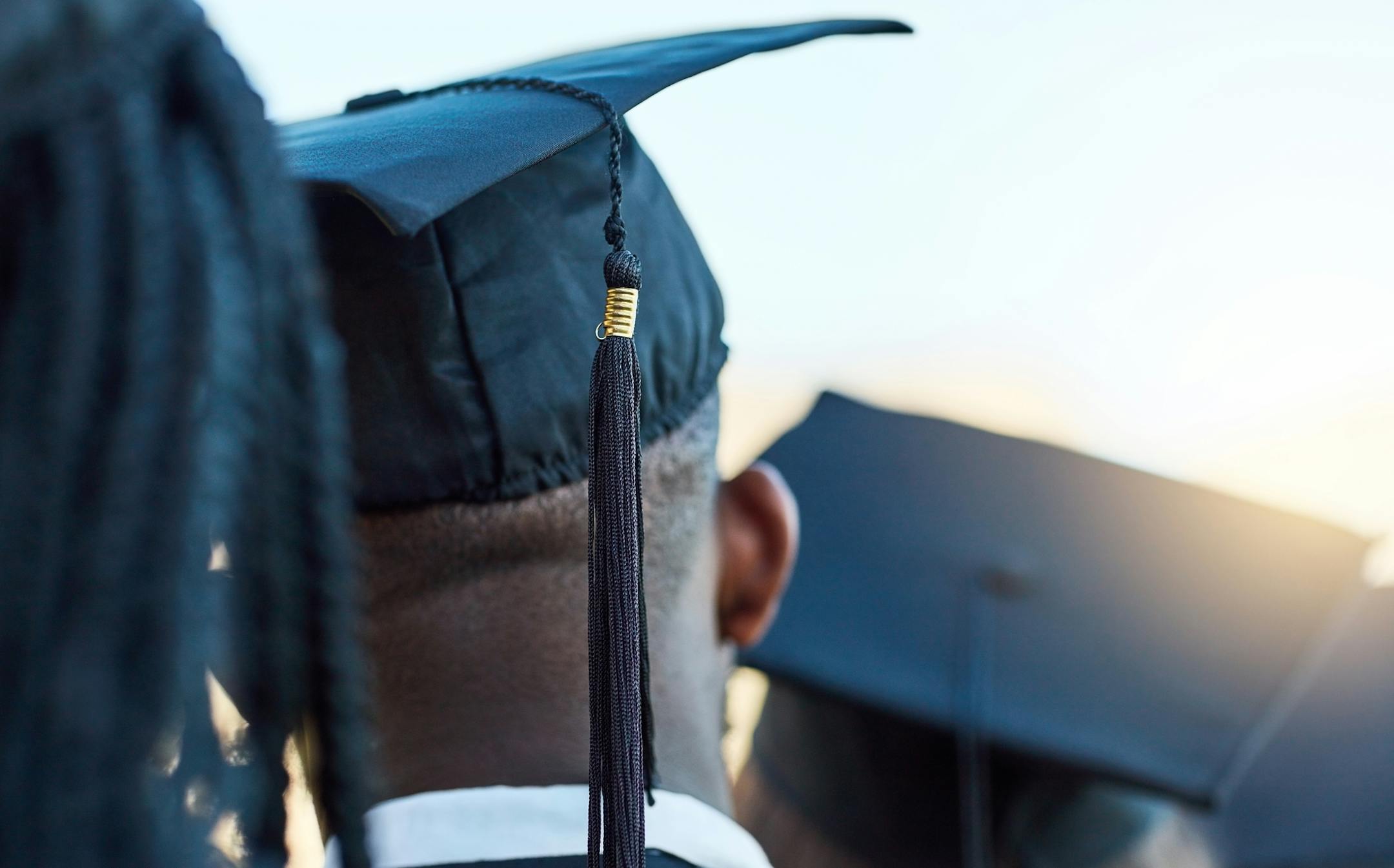 Rearview shot of a group of students standing in a line on graduation day