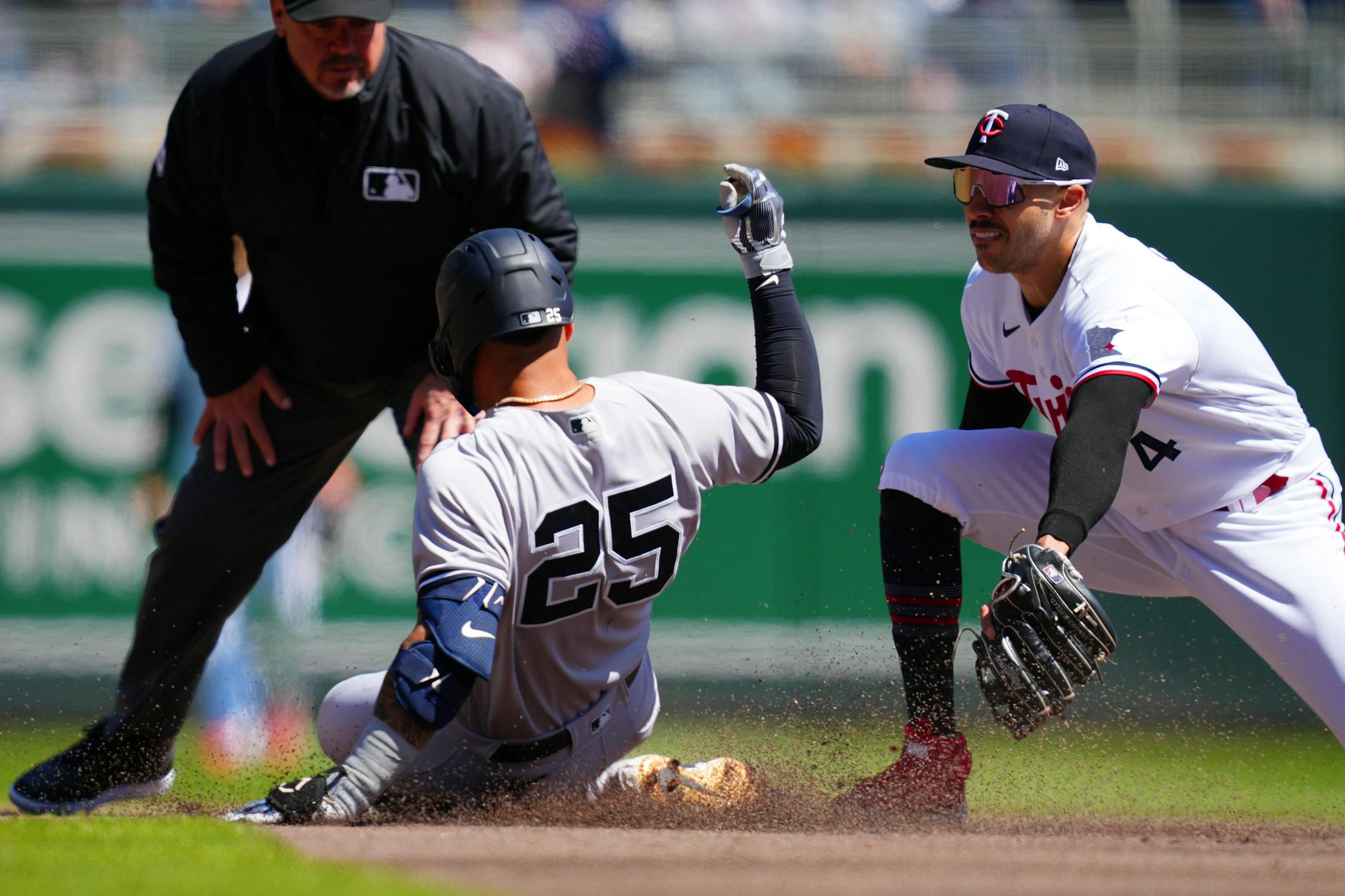 New York Yankees second baseman Gleyber Torres (25) slides past Minnesota Twins shortstop Carlos Correa (4) to go on to third from a throwing error by second baseman Nick Gordon (1) in the second inning.