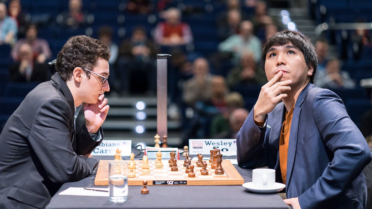 Grandmaster Wesley So, right, checks the status of other games being shown on a video screen at the London Chess Classic on Saturday, as his opponent Fabiano Caruana contemplates his next move.