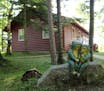The two-bedroom cabin near Finlayson, Minn., with red log siding and bay windows facing the sunset.