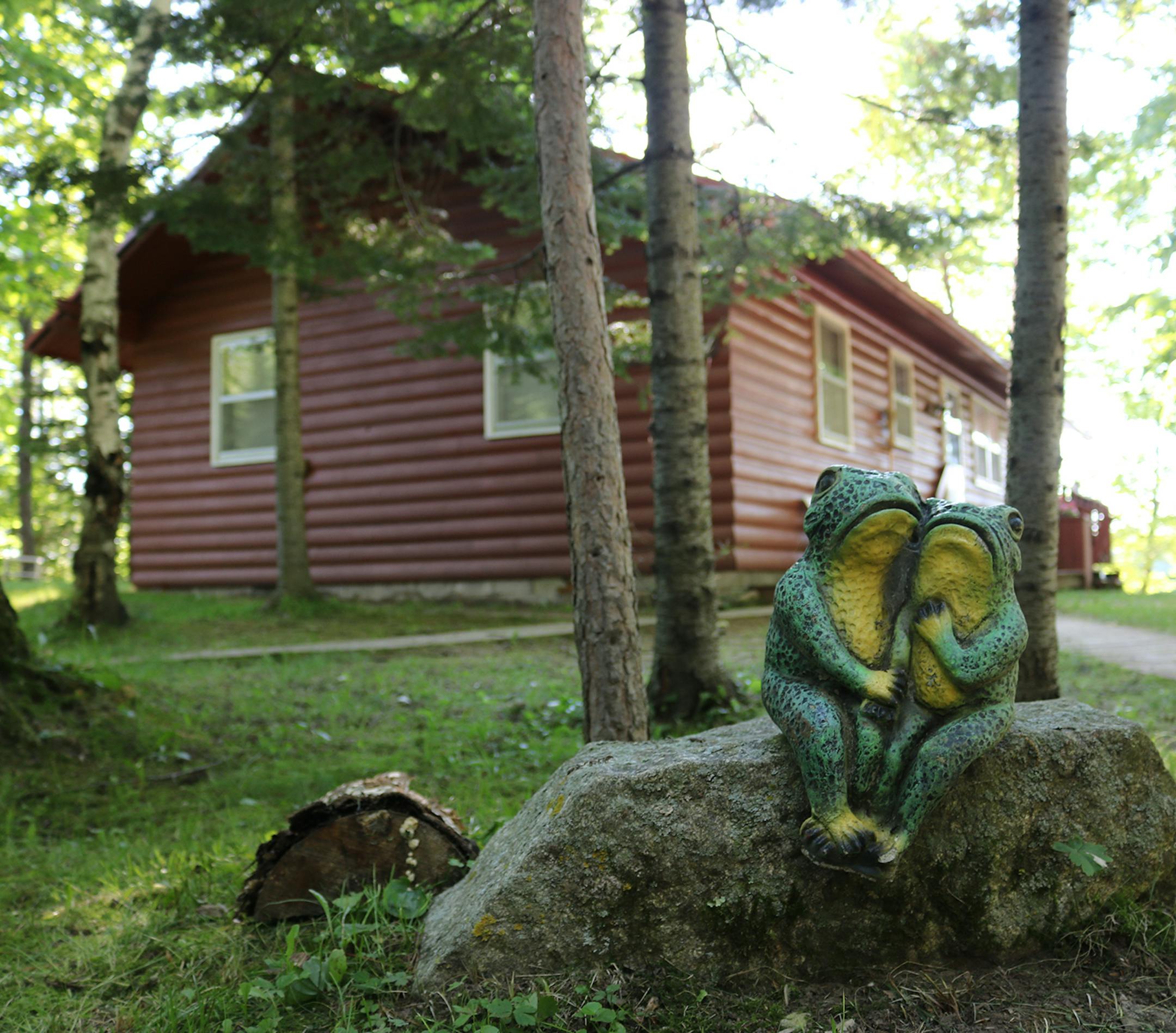 The two-bedroom cabin near Finlayson, Minn., with red log siding and bay windows facing the sunset.
