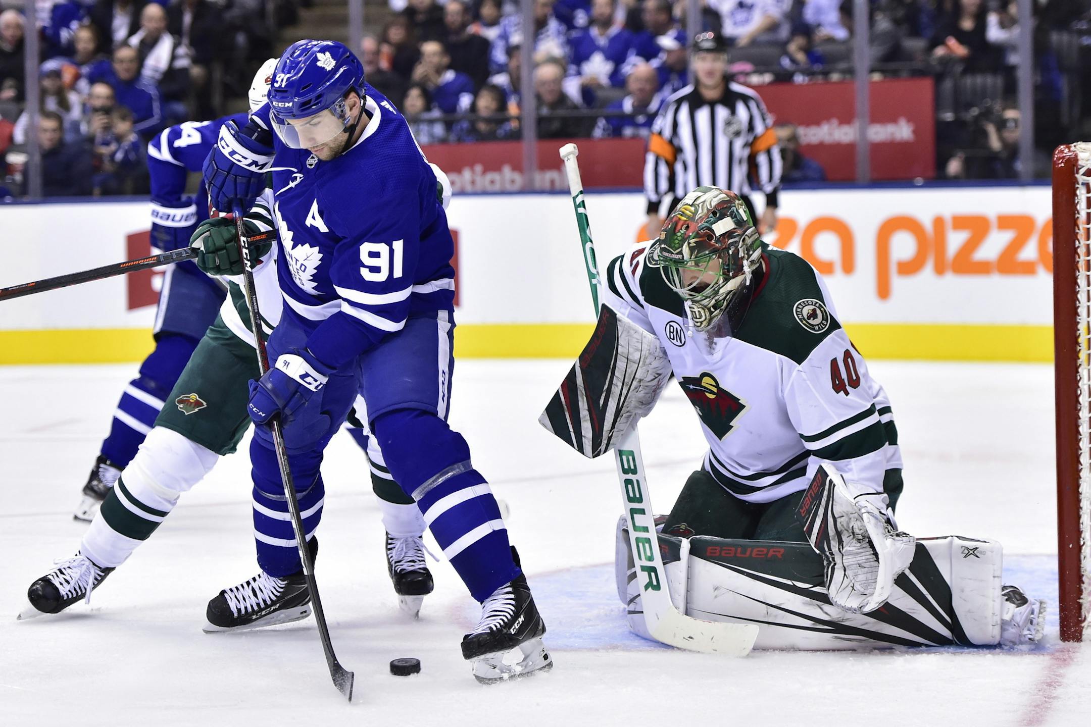 Toronto Maple Leafs center John Tavares (91) tries to locate the puck in front of Minnesota Wild goaltender Devan Dubnyk (40) during the second period of an NHL hockey game, Thursday, Jan. 3, 2019 in Toronto. (Frank Gunn/The Canadian Press via AP)