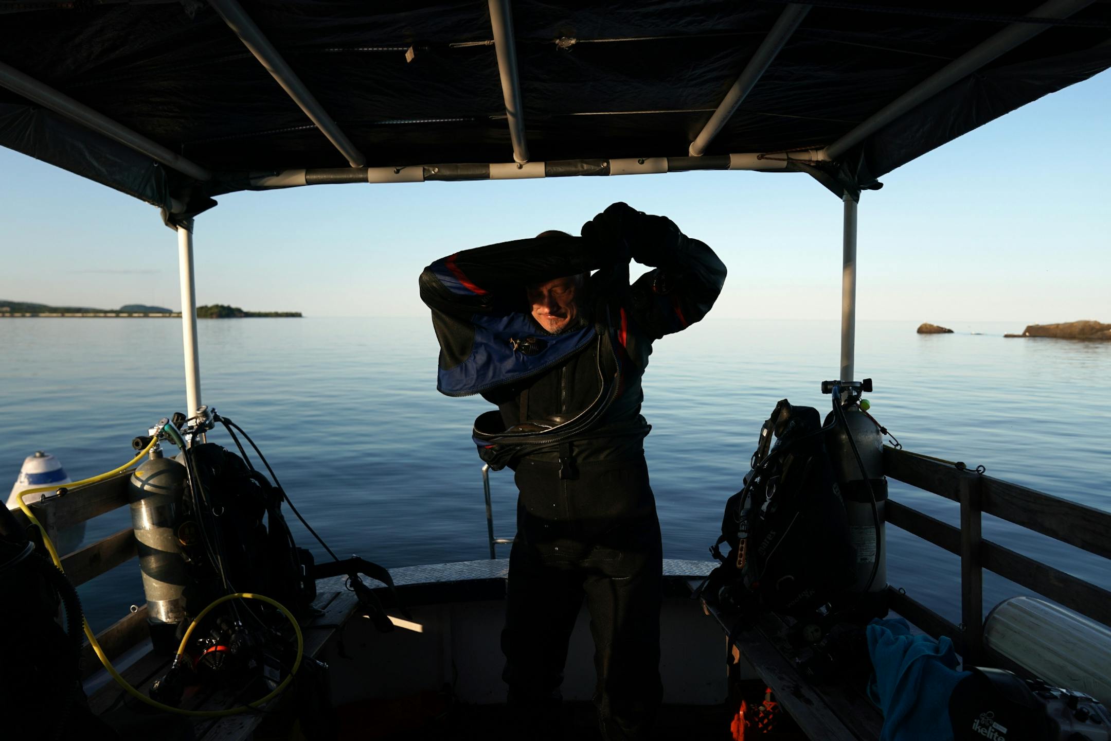 Jack Decker, a diver with the Great Lakes Shipwreck Preservation Society from Clear Lake, Iowa, pulled off his drysuit on the group's boat the RV Preservation after diving the Hesper.