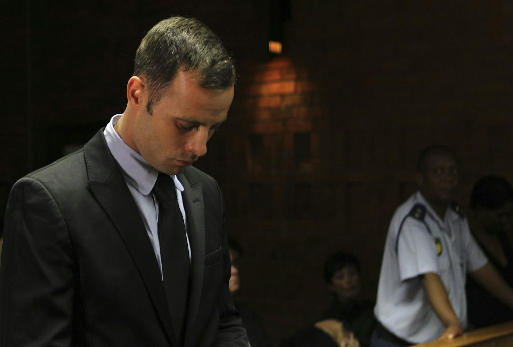 Olympic athlete Oscar Pistorius stands inside the court as a police officer looks on during his bail hearing at the magistrate court in Pretoria, South Africa, Wednesday, Feb. 20, 2013. A South African judge says defense lawyers will need to offer "exceptional" reasons to convince him to grant bail for Oscar Pistorius, when a hearing resumes Wednesday.